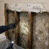 Hidden water damage behind bathroom tiles caused by waterproofing failure