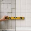 Common bathroom tiling mistakes shown with uneven crooked tiles beside neat straight tiling